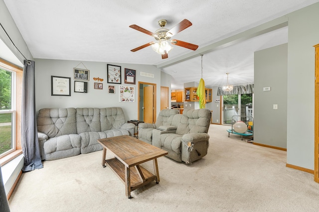 733 N Main St, Evart, MI 49631 - carpeted living area with healthy amount of natural light, ceiling fan, vaulted ceiling, and a chandelier