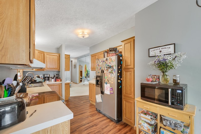 733 N Main St, Evart, MI 49631 - kitchen featuring stainless steel fridge with ice dispenser, light wood-style floors, light countertops, and a textured ceiling