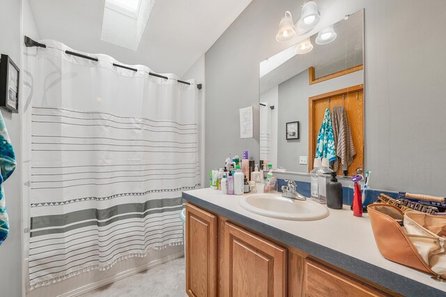 733 N Main St, Evart, MI 49631 - full bathroom with vanity, a skylight, a shower with curtain, and vaulted ceiling