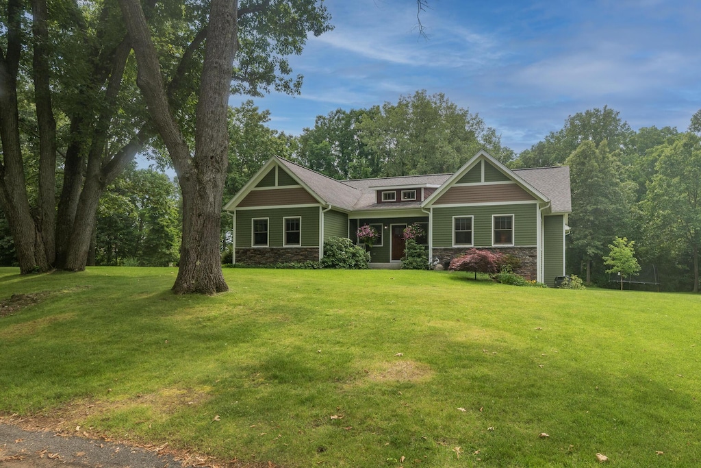 10016 Oshtemo Ct, Kalamazoo, MI 49009 - craftsman-style home with stone siding and a front lawn