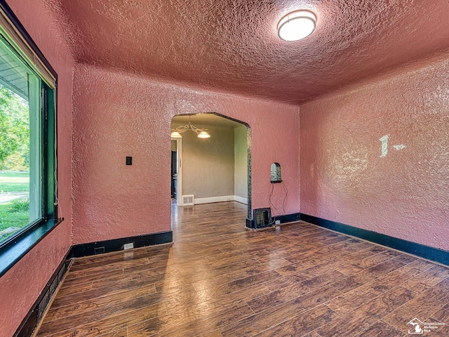 3375 Clinton Way, Jackson, MI 49201 - unfurnished room featuring a textured wall, arched walkways, wood finished floors, and a textured ceiling