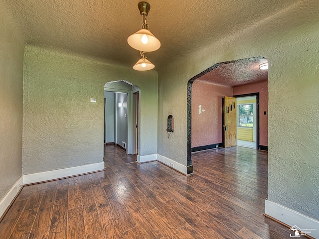 3375 Clinton Way, Jackson, MI 49201 - unfurnished room with a textured wall, arched walkways, a textured ceiling, and wood finished floors