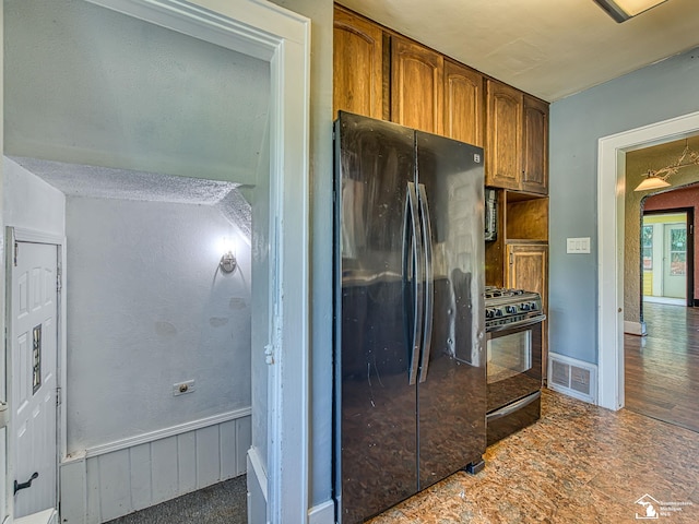 3375 Clinton Way, Jackson, MI 49201 - kitchen with black appliances, brown cabinetry, and arched walkways