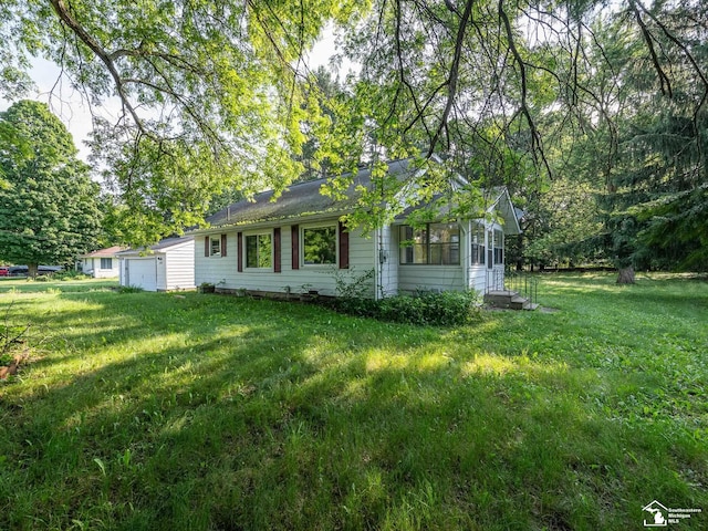 3375 Clinton Way, Jackson, MI 49201 - view of front of house featuring a front yard, a garage, and a sunroom