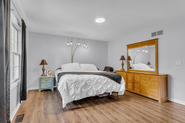 2151 Glenwood Ct, Brooklyn, MI 49230 - bedroom featuring wood finished floors and a chandelier