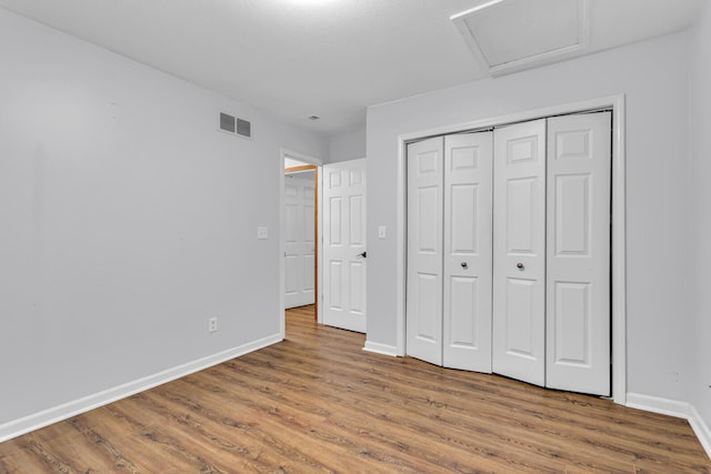 2151 Glenwood Ct, Brooklyn, MI 49230 - unfurnished bedroom featuring wood finished floors, attic access, and a closet