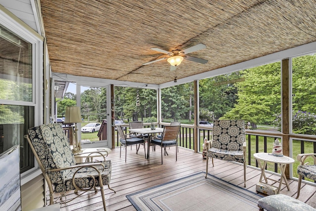 11277 N Dr, Brooklyn, MI 49230 - wooden deck with outdoor dining space, a ceiling fan, and view of wooded area