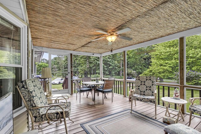 11277 N Dr, Brooklyn, MI 49230 - wooden deck with outdoor dining space, a ceiling fan, and view of wooded area
