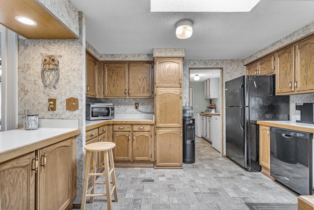 11277 N Dr, Brooklyn, MI 49230 - kitchen featuring black appliances, light countertops, wallpapered walls, brick patterned floors, and brown cabinets