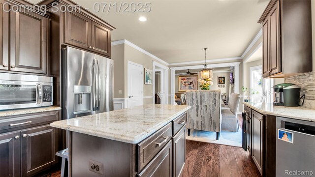 19492 Springbrook Dr, Macomb, MI 48044 - kitchen with stainless steel appliances, crown molding, dark wood finished floors, light stone counters, and dark brown cabinets