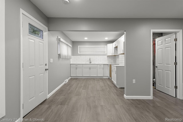 1587 Reo Ave, Lincoln Park, MI 48146 - kitchen featuring light wood-type flooring, white cabinetry, decorative backsplash, recessed lighting, and light countertops