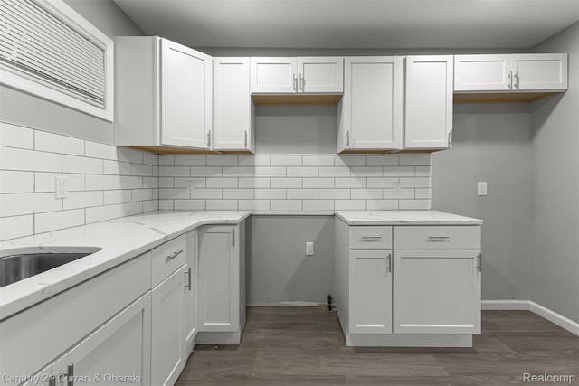 1587 Reo Ave, Lincoln Park, MI 48146 - kitchen with light stone countertops, dark wood-type flooring, tasteful backsplash, and white cabinets