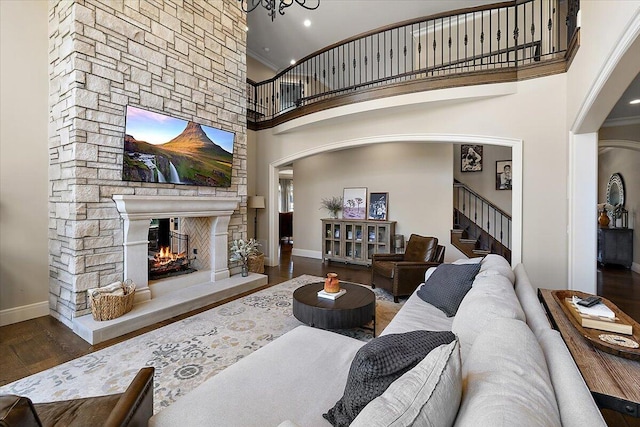 1988 Christenbury Ct, Rochester, MI 48306 - living area featuring a stone fireplace, stairs, wood finished floors, ornamental molding, and arched walkways
