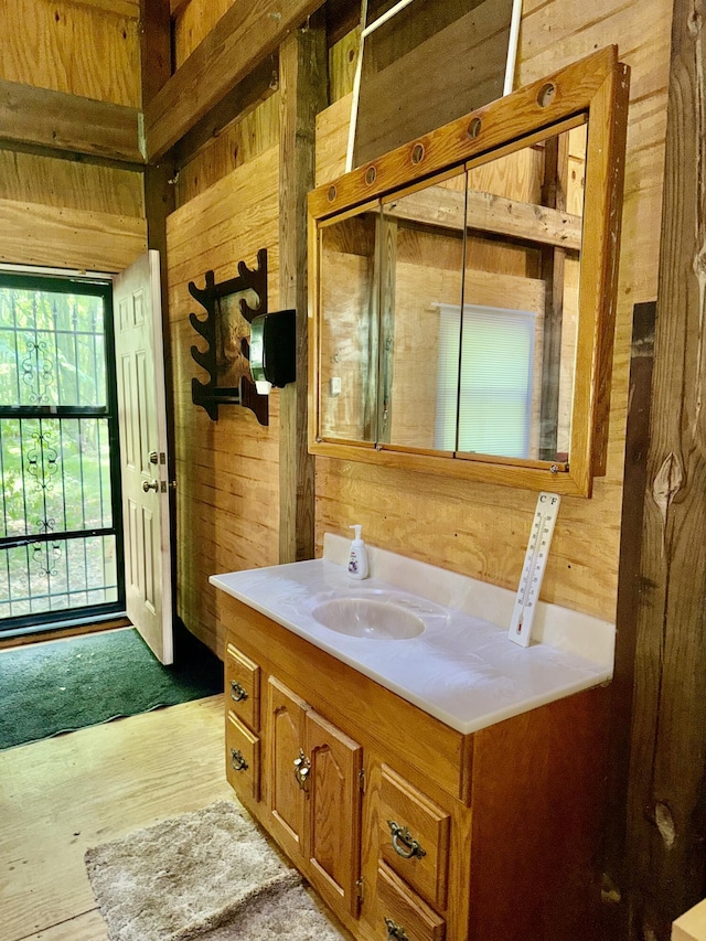 23266 Hayes Rd, Big Rapids, MI 49307 - bathroom featuring wooden walls, vanity, and wood finished floors