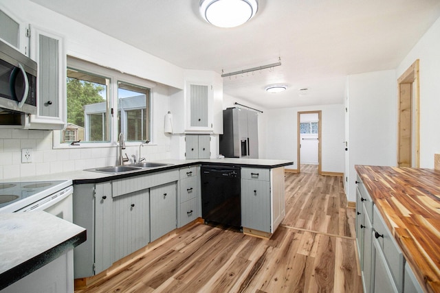 1722 Benson, Fountain, MI 49410 - kitchen with stainless steel appliances, butcher block countertops, a peninsula, light wood finished floors, and decorative backsplash