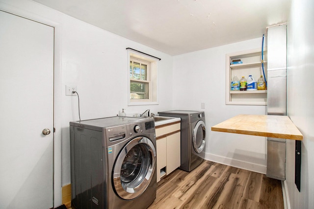 1722 Benson, Fountain, MI 49410 - washroom featuring independent washer and dryer, light wood-type flooring, and cabinet space