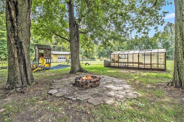 1722 Benson, Fountain, MI 49410 - view of yard with an exterior structure, an outdoor fire pit, an outdoor structure, and view of scattered trees