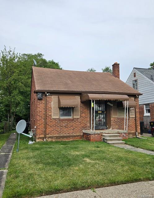 8296 Prest St, Detroit, MI 48228 - view of front of property featuring brick siding, a front yard, a chimney, a porch, and roof with shingles