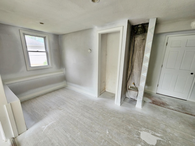 730 W Mohawk Trl, White Cloud, MI 49349 - unfurnished bedroom with a textured ceiling and wood finished floors