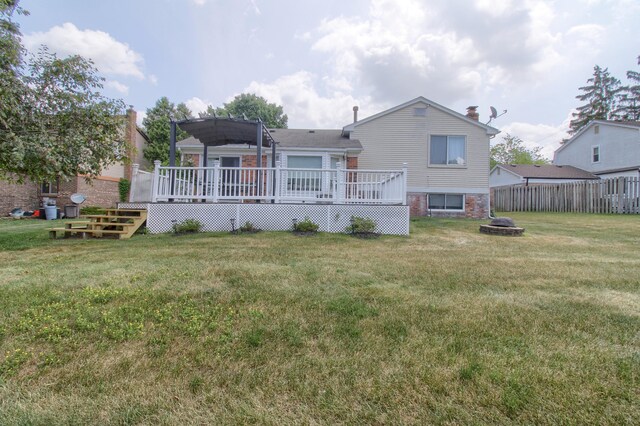 13947 Ashurst St, Livonia, MI 48154 - back of property featuring an outdoor fire pit, a wooden deck, and a chimney