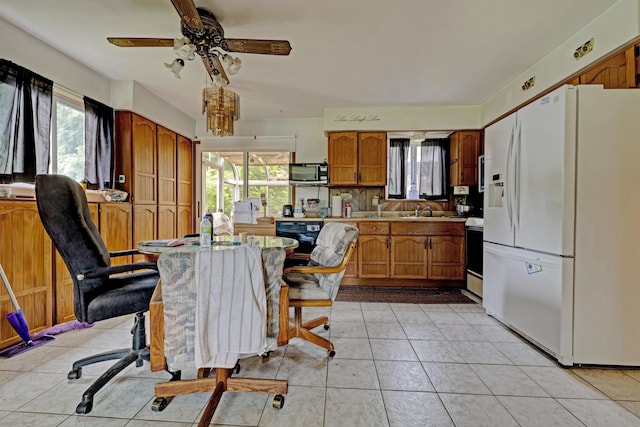 3618 Rohr Rd, Lake Orion, MI 48359 - kitchen with white refrigerator with ice dispenser, stainless steel microwave, brown cabinets, and plenty of natural light