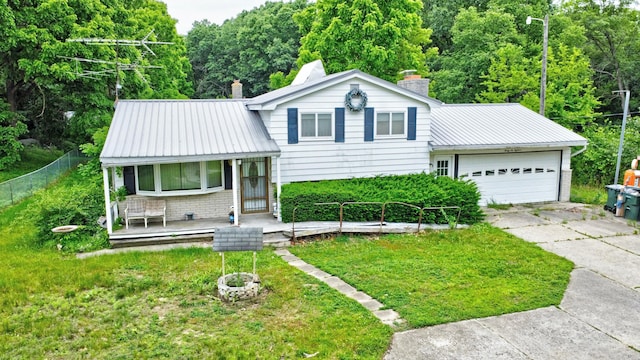 3618 Rohr Rd, Lake Orion, MI 48359 - split level home featuring a porch, concrete driveway, a chimney, a garage, and a metal roof