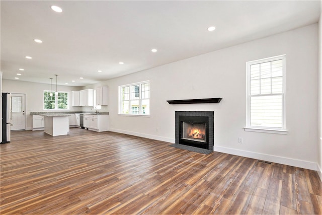 209 N 7th St, Ann Arbor, MI 48103 - unfurnished living room featuring dark wood-style floors, recessed lighting, and a fireplace with flush hearth