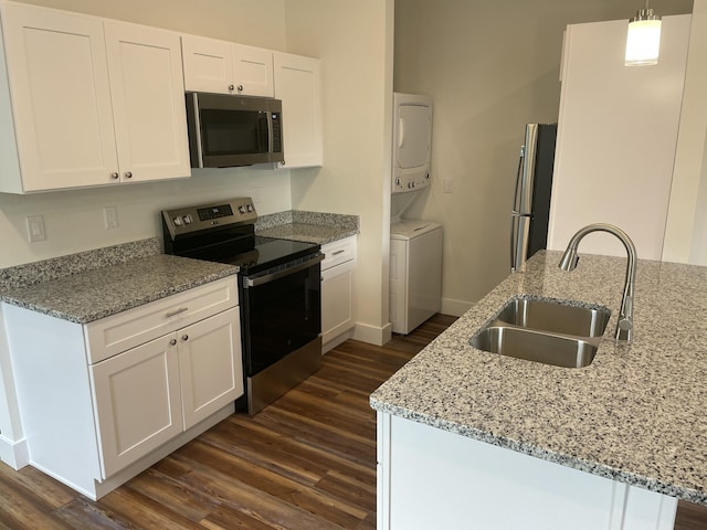 209 N 7th St, Ann Arbor, MI 48103 - kitchen featuring stainless steel appliances, stacked washer / dryer, dark wood finished floors, and white cabinets