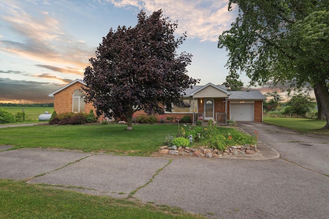 200 Begole Rd, Milan, MI 48160 - view of front facade with brick siding, driveway, an attached garage, and a front lawn