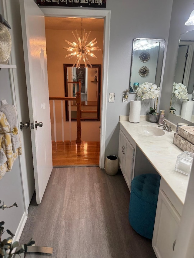 2008 Beekman Ct, Flushing, MI 48532 - bathroom featuring wood finished floors, vanity, and a chandelier