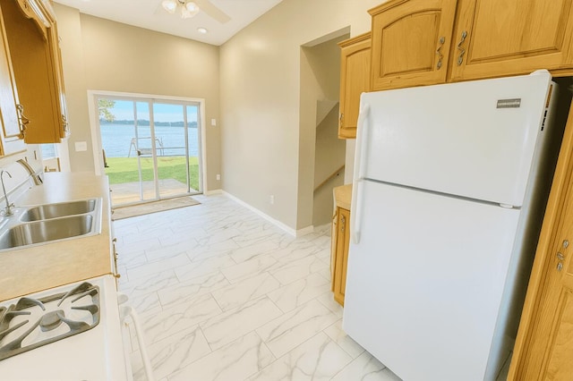 238 Cooks Lndg, Michigan Center, MI 49254 - kitchen with white appliances, light marble finish floors, light countertops, a water view, and a ceiling fan