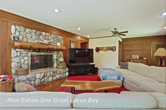 1360 Delta Dr, Saginaw, MI 48638 - living room with wood walls, ceiling fan, wood finished floors, recessed lighting, and a stone fireplace