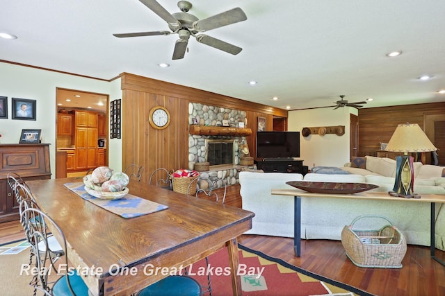 1360 Delta Dr, Saginaw, MI 48638 - dining space with a ceiling fan, wood finished floors, recessed lighting, wooden walls, and a stone fireplace