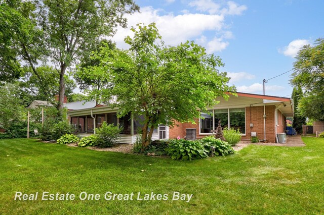1360 Delta Dr, Saginaw, MI 48638 - rear view of house featuring a lawn and brick siding