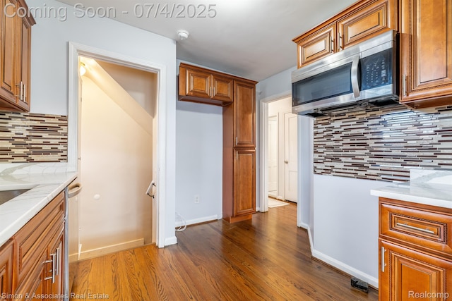 3101 Roosevelt St, Dearborn, MI 48124 - kitchen featuring stainless steel microwave, backsplash, brown cabinets, and dark wood finished floors
