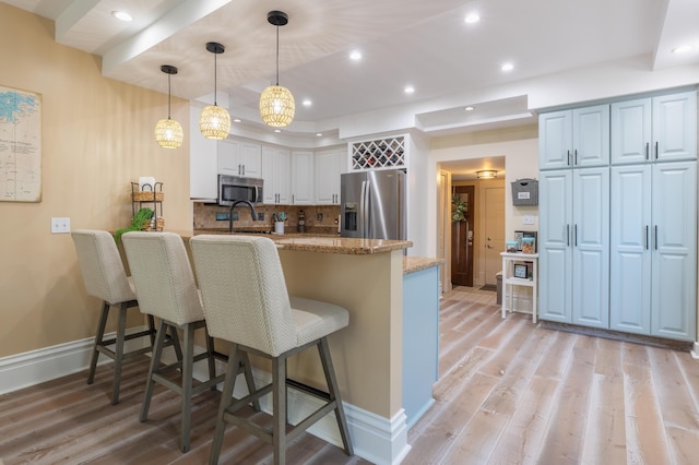 464 Kalamazoo St, South Haven, MI 49090 - kitchen with stainless steel appliances, a peninsula, recessed lighting, a kitchen breakfast bar, and light wood finished floors