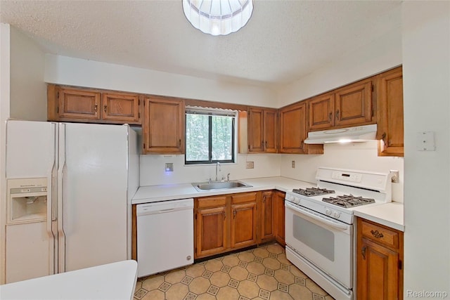 11589 Lombardy Ct, Pinckney, MI 48169 - kitchen with white appliances, under cabinet range hood, brown cabinetry, light countertops, and a textured ceiling