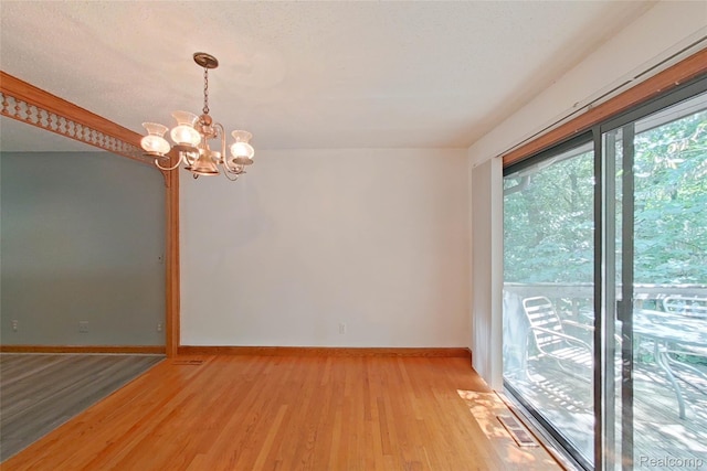 11589 Lombardy Ct, Pinckney, MI 48169 - unfurnished room with a chandelier and light wood finished floors