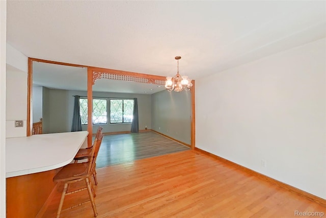 11589 Lombardy Ct, Pinckney, MI 48169 - unfurnished dining area featuring light wood finished floors and a chandelier