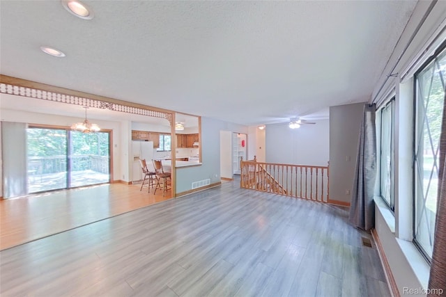 11589 Lombardy Ct, Pinckney, MI 48169 - unfurnished living room with a chandelier, wood finished floors, a ceiling fan, and recessed lighting