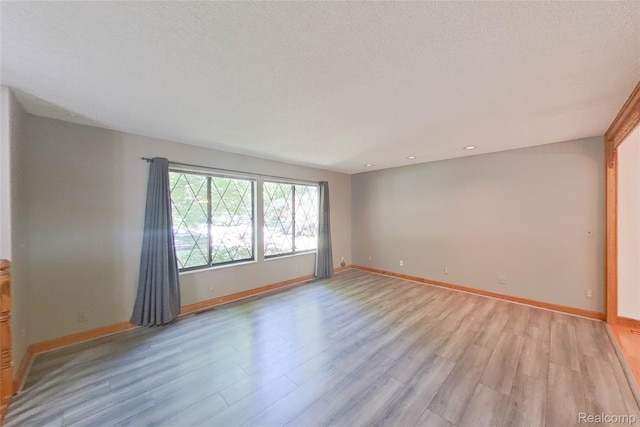 11589 Lombardy Ct, Pinckney, MI 48169 - empty room with light wood-type flooring, recessed lighting, and a textured ceiling