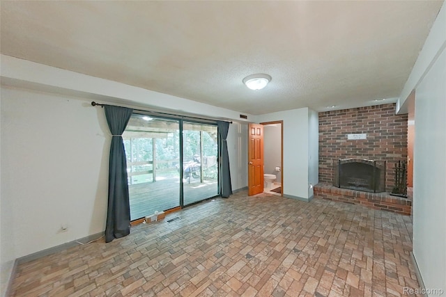 11589 Lombardy Ct, Pinckney, MI 48169 - unfurnished living room with a brick fireplace, brick patterned flooring, and a textured ceiling