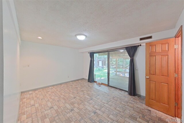 11589 Lombardy Ct, Pinckney, MI 48169 - empty room featuring brick patterned floors and a textured ceiling