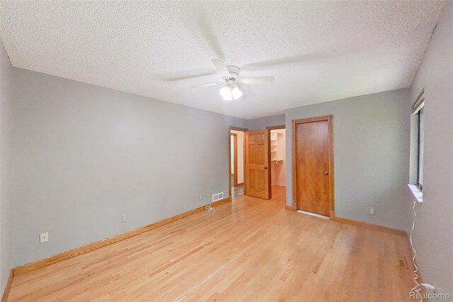 11589 Lombardy Ct, Pinckney, MI 48169 - unfurnished bedroom featuring wood finished floors, a textured ceiling, a closet, and ceiling fan