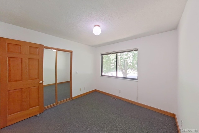 11589 Lombardy Ct, Pinckney, MI 48169 - unfurnished bedroom with carpet, a closet, and a textured ceiling