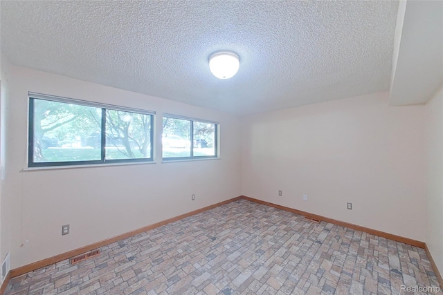 11589 Lombardy Ct, Pinckney, MI 48169 - empty room with a textured ceiling and brick patterned flooring