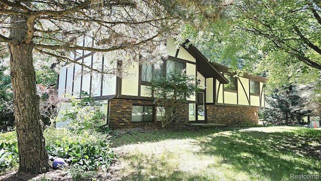 11589 Lombardy Ct, Pinckney, MI 48169 - view of property exterior with brick siding and a yard