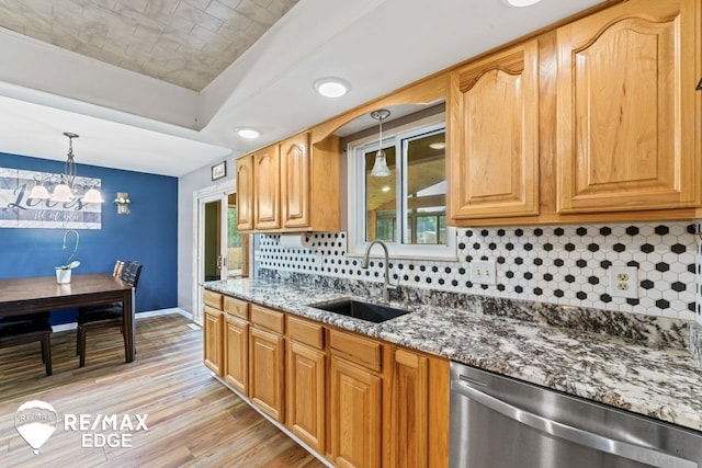 7226 Junction Rd, Frankenmuth, MI 48722 - kitchen with stainless steel dishwasher, dark stone counters, light wood-style flooring, backsplash, and pendant lighting