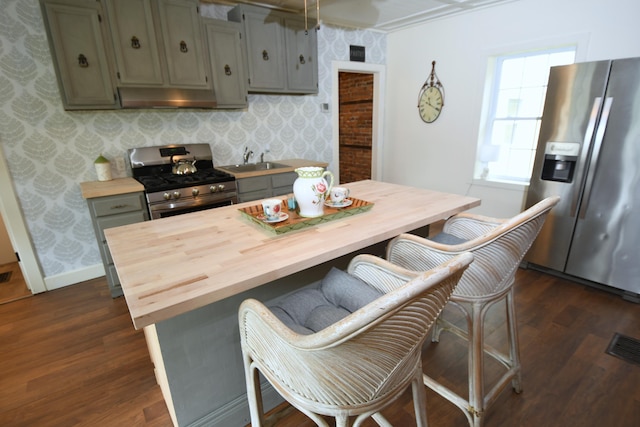 514 N Kalamazoo St, Paw Paw, MI 49079 - kitchen with appliances with stainless steel finishes, wooden counters, dark wood-style floors, under cabinet range hood, and wallpapered walls