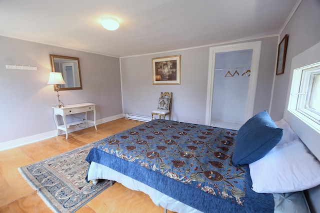 514 N Kalamazoo St, Paw Paw, MI 49079 - bedroom with baseboard heating, a closet, wood finished floors, and ornamental molding